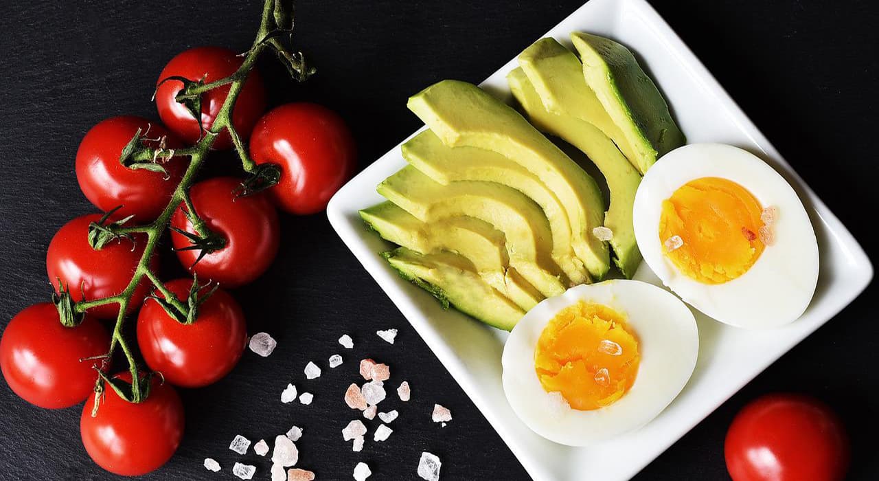 Avocado and eggs in a plate of tomatoes